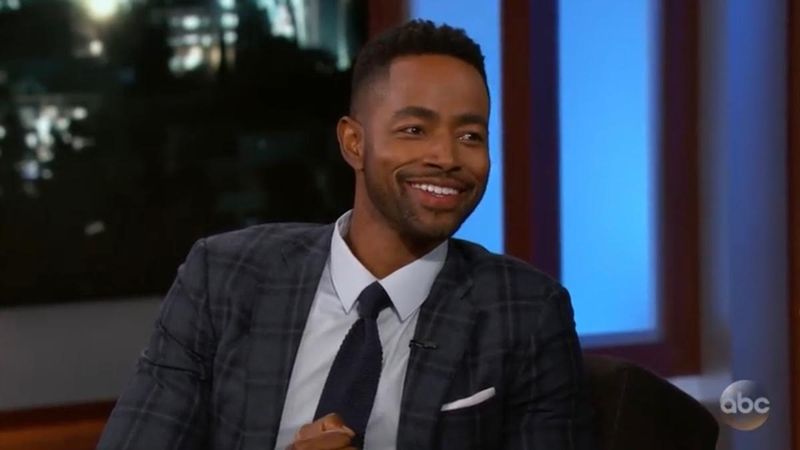 Jay Ellis sjedi u odijelu i kravati