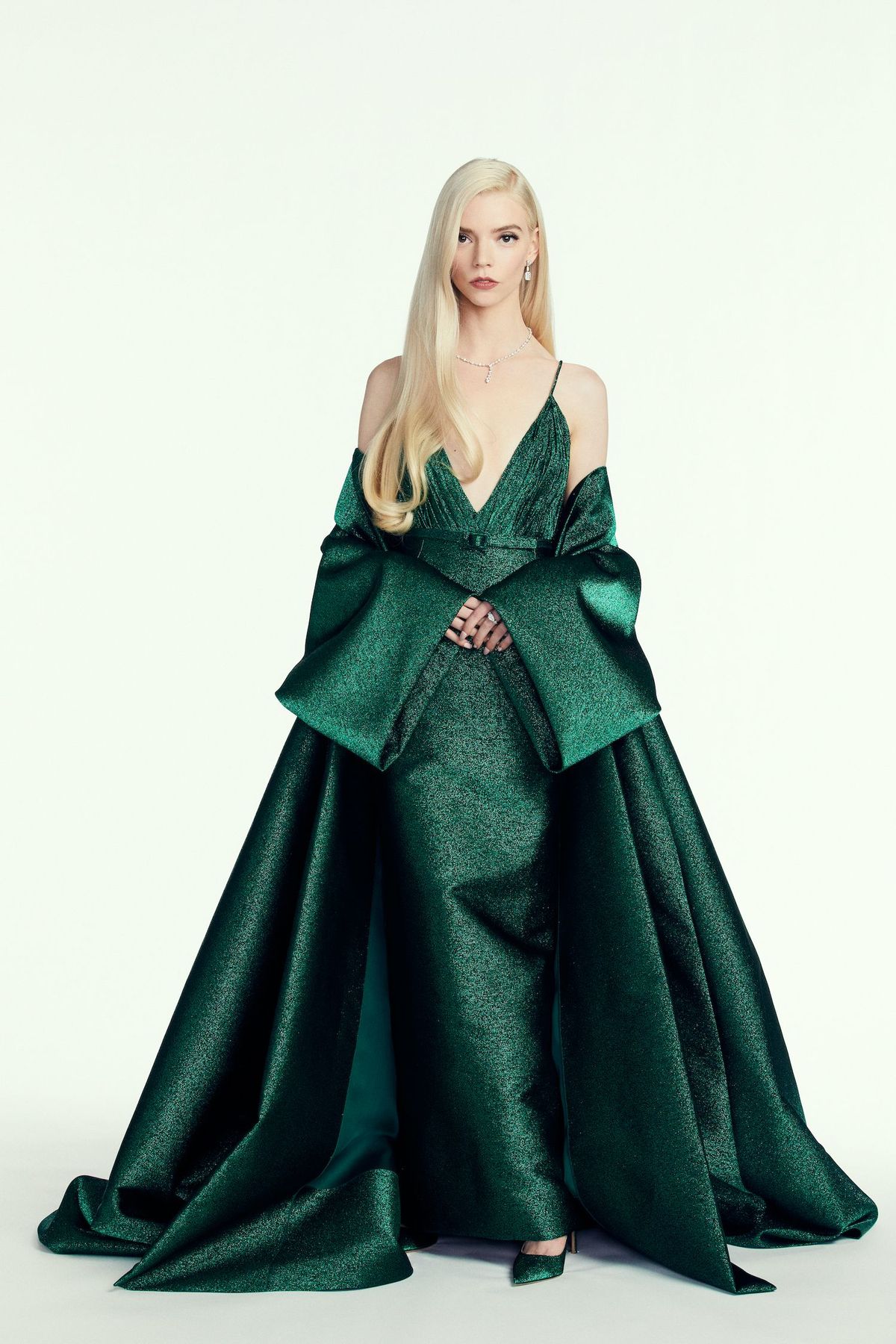 Anya Taylor radość w szmaragdowej sukni do podłogi, diamentach i na białym tle