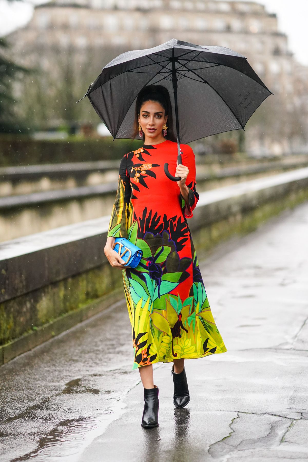 paris, frankrig 01 marts jessica kahawaty bærer en rød og grøn blomsterprint kjole, en blå valentino taske, sorte læder spidse støvler, øreringe, uden for valentino, under paris fashion week dametøj fallwinter 20202021, den 1. marts 2020 i Paris, Frankrig foto af edward berthelotgetty billeder