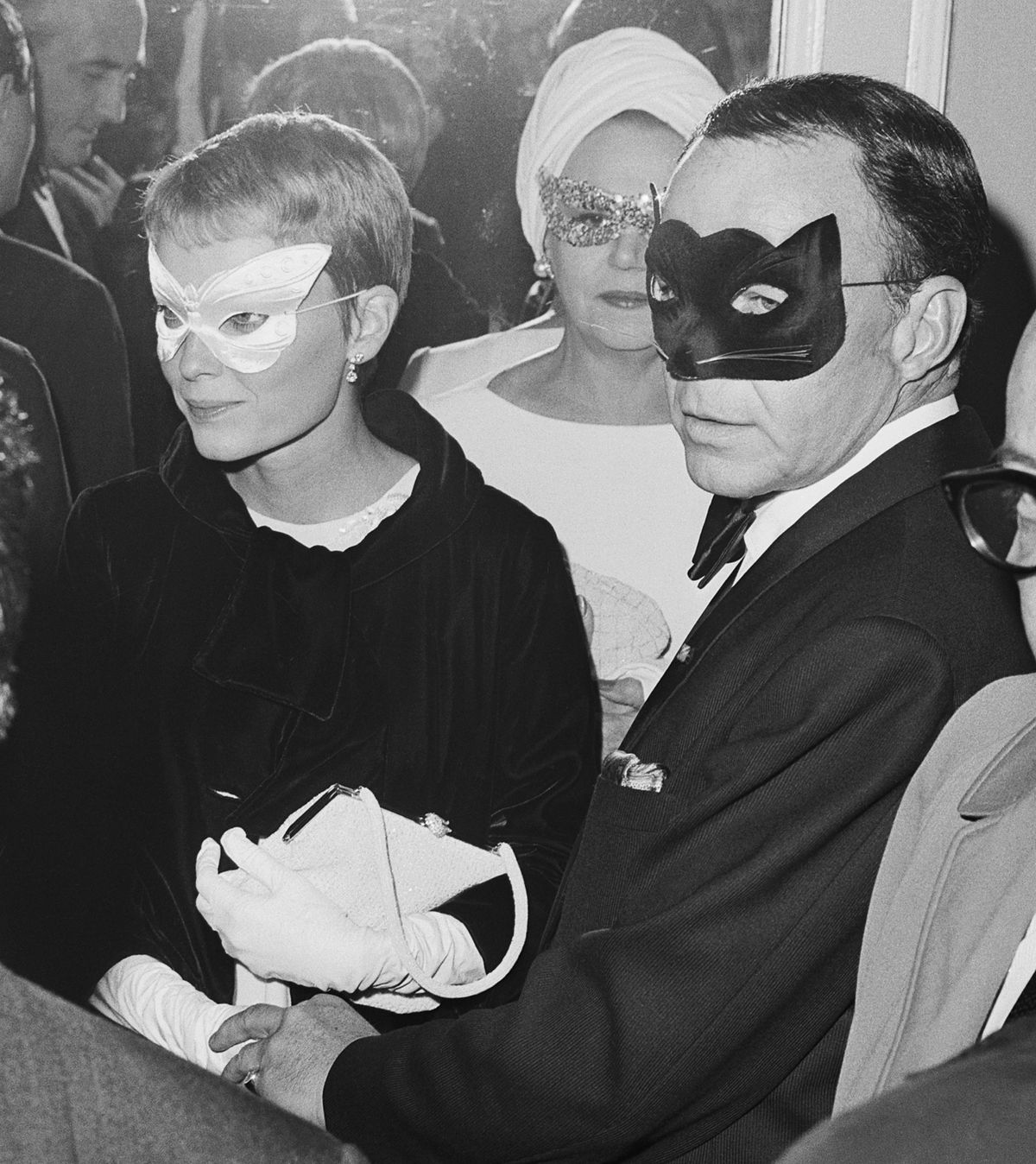 Frank Sinatra e Mia Farrow usando máscaras